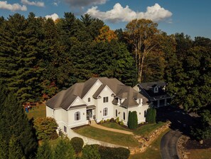 Une grande maison à deux étages, dotée d’une pelouse bien entretenue et d’une allée menant à l’entrée.