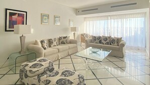 A living room with a sofa set, a coffee table, a TV, and a lamp.
