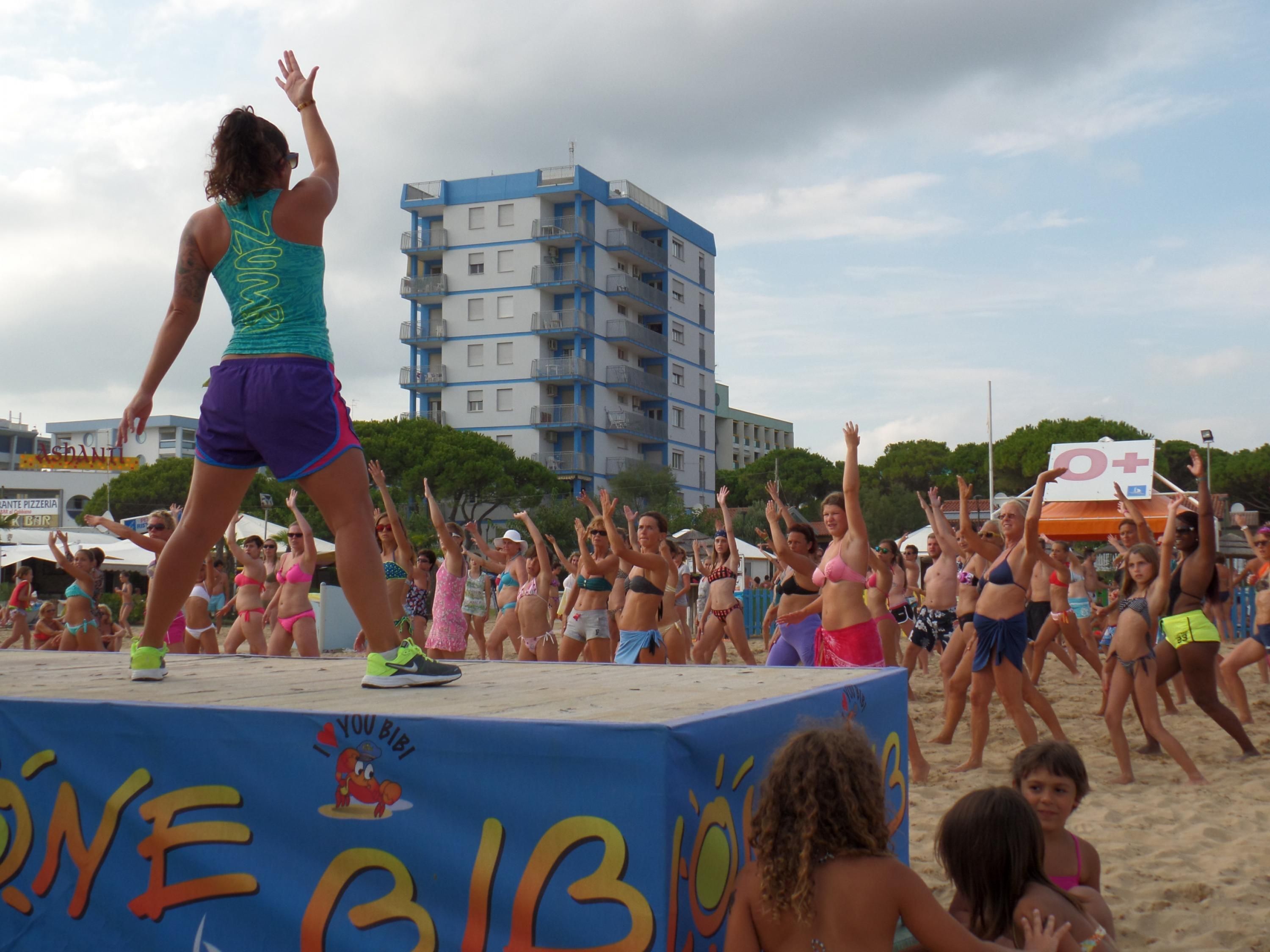 A beach event with a stage and a crowd.