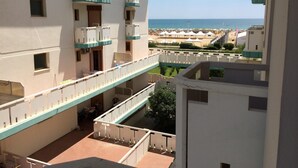 Een hotel met meerdere verdiepingen en balkons met uitzicht op een strand.