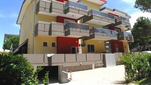 En flervåningsbostadsbyggnad med balkonger, ett platt tak och en enkel fasad.