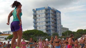 A beach event with a stage and a crowd. - Felice CPT in Bibione (San Michele al Tagliamento)