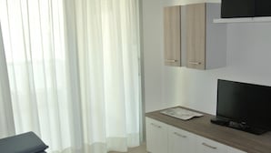 Une chambre à coucher moderne avec un lit, une télévision et une armoire en bois.