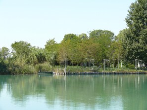 Un lac paisible avec un quai et un petit bateau.