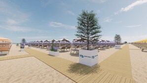 Ein Strandabschnitt mit Reihen von Liegestühlen unter Sonnenschirmen, einer Holzpromenade und einem großen Baum in der Mitte.