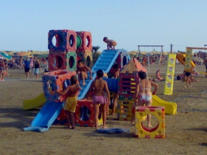 Kids can play on colorful play structures with slides and climbing elements in this family-friendly beach area.