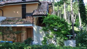A two-story house with a tiled roof, a chimney, and a balcony.