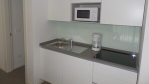 A compact kitchen with a microwave, sink, and coffee maker. - Villa Onda D in Bibione (San Michele al Tagliamento)
