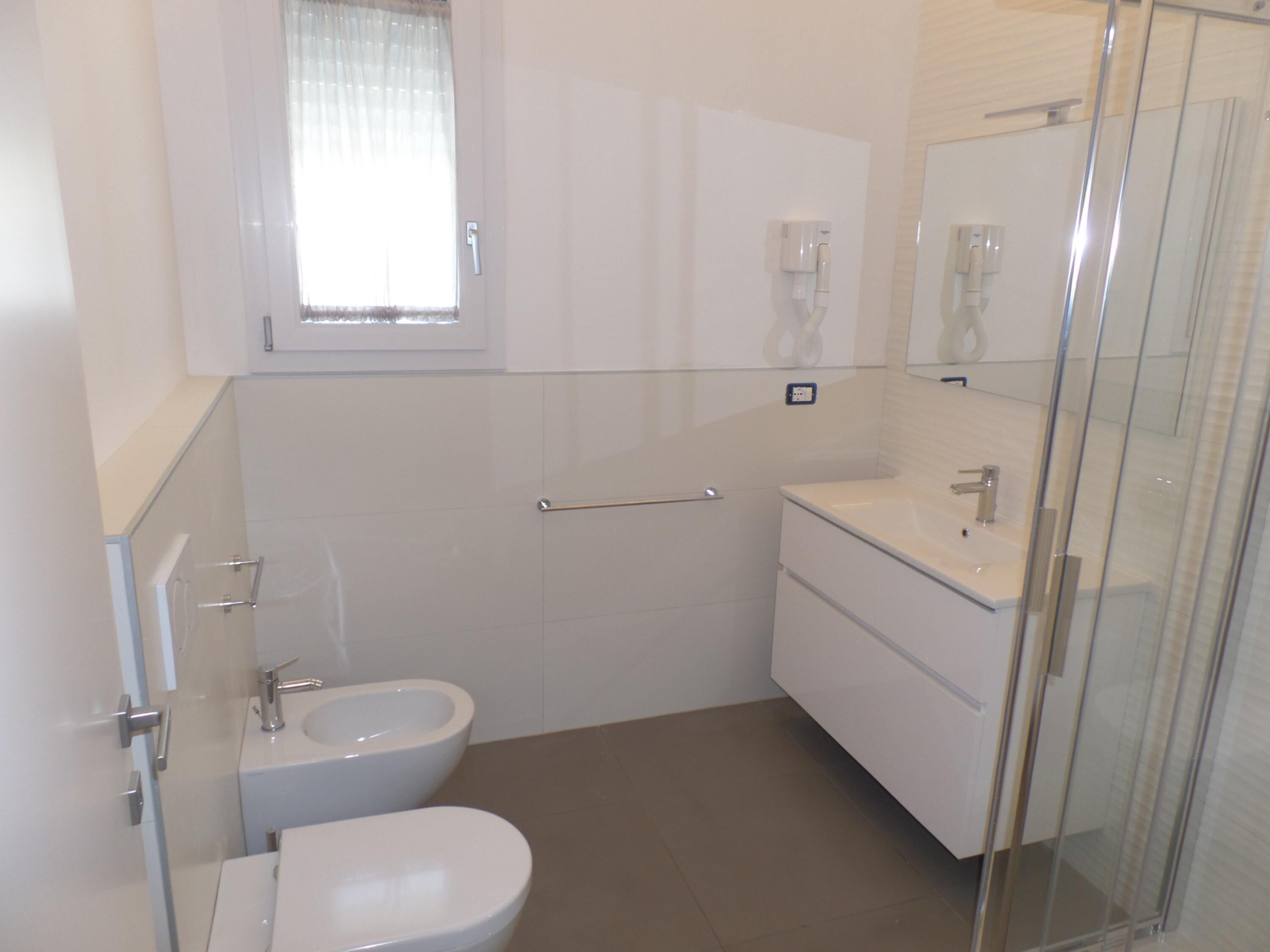 Une salle de bain moderne équipée de toilettes, d’un bidet et d’un lavabo.