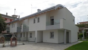 A modern two-story building with a flat roof, large windows, and a balcony. - Villa Onda D in Bibione (San Michele al Tagliamento)