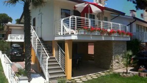 A two-story house with a balcony, a staircase, and a satellite dish.
