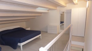 A bedroom with a bed, a dresser, and a wardrobe. - Melograno C Mans in Bibione (San Michele al Tagliamento)