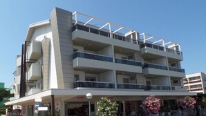 Un immeuble à plusieurs étages, doté de balcons et d’une entrée au niveau du sol.