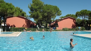 A swimming pool area with people swimming and relaxing. - Azzurro 346 in Bibione (San Michele al Tagliamento)