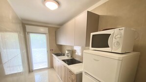 Eine moderne Küche mit eingebauter Mikrowelle, einer Kaffeemaschine und einem Kühlschrank.