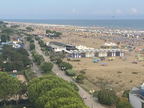 A beachside area with beach huts, a pathway, and a view of the beach and sea. - Villa Beba 1P in Bibione (San Michele al Tagliamento)