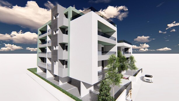Een modern meerhoogappartementencomplex met balkons, een parkeerplaats en een witte auto.