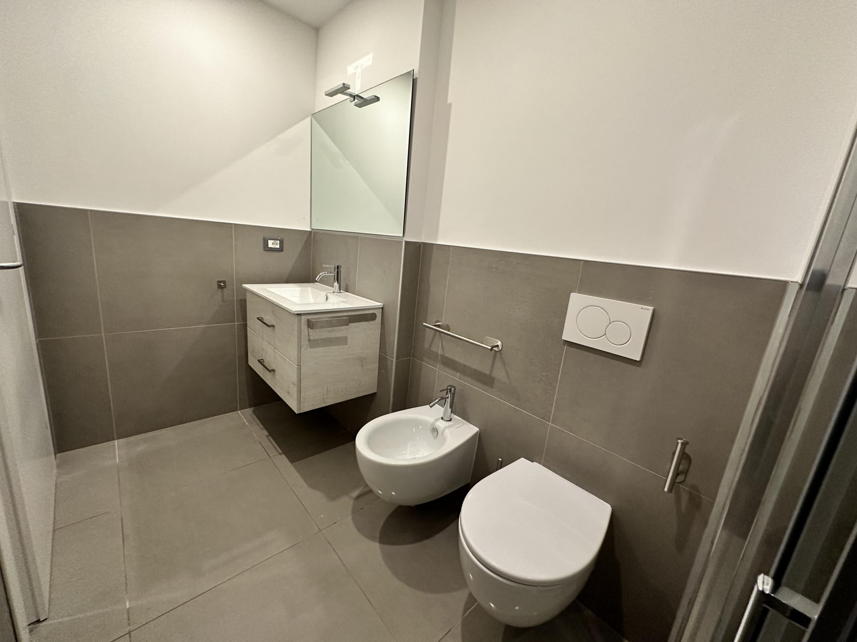 Une salle de bain moderne équipée de toilettes, d’un bidet et d’un meuble-lavabo.