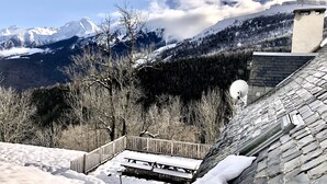 A snowy mountain landscape with a wooden deck and picnic tables.