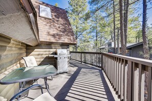A wooden deck with a glass table and chairs, a grill, and a view of trees. - Hike, Bike & ATV: Munds Park Cabin! (Munds Park)