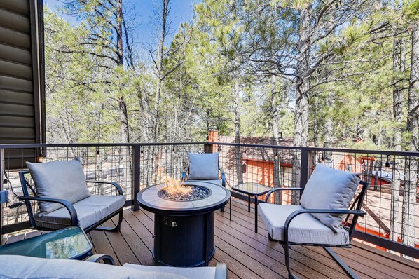 A deck with a fire pit, two chairs, and a table. - Hike, Bike & ATV: Munds Park Cabin! (Munds Park)