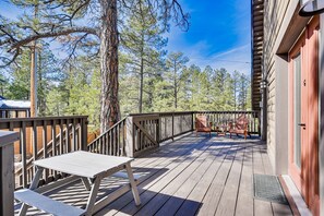 A wooden deck with a table and chairs, overlooking a forested area. - Hike, Bike & ATV: Munds Park Cabin! (Munds Park)