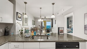 A modern kitchen with granite countertops, stainless steel appliances, and pendant lighting. - Oceanfront ex large balcony, Amazing panoramic views of Gulf from 16th floor (Panama City Beach)