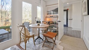 A modern interior with a round table, two chairs, and a bookshelf.