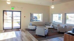 A modern lobby with a reception desk, seating area, and large windows. - Comfort Inn Battle Mountain - Midway Between Elko and Winnemucca (Battle Mountain)
