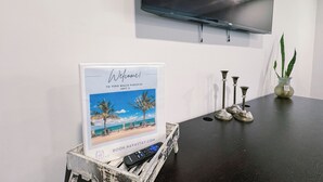 Señal de bienvenida para Vero Beach Paradise, Unidad 3, con un control remoto sobre un caja de madera.