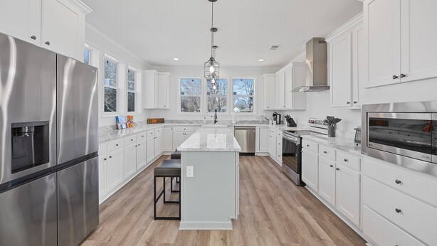 A modern kitchen with white cabinetry, stainless steel appliances, and a central island. - Lakefront House with Ping Pong, Pool Table, & Front Patio Stunning Views (Nevada)