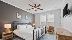 A bedroom with a bed, nightstand, lamp, chair, desk, and ceiling fan. - Lakefront House with Ping Pong, Pool Table, & Front Patio Stunning Views (Nevada)