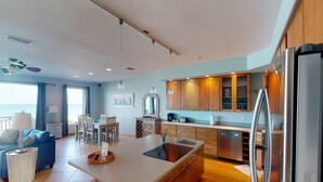 Een moderne keuken met een centraal eiland, houten kastjes en een roestvrijstalen koelkast.