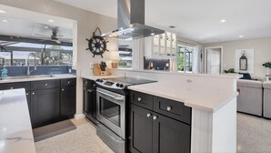 A modern kitchen with dark cabinets, a stainless steel range, and a large island. - New Listing! Charlotte Harbor Area Resort, 120mi to Disney & 134mi to Universal - GRH595427 (Punta Gorda)