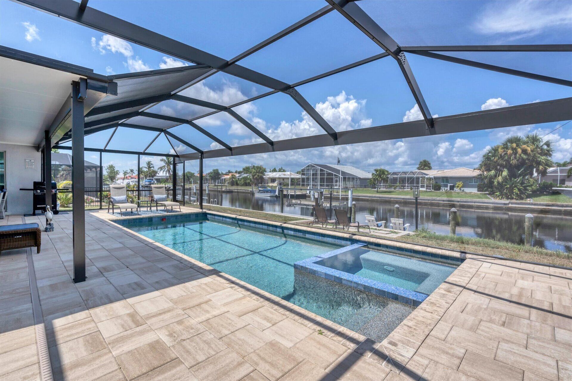 Una piscina cubierta al aire libre con vistas a un lago y casas al fondo.