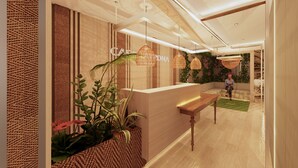 Un área de recepción con un mostrador de madera, paneles de pared tejidos y lámparas de mimbre colgantes.