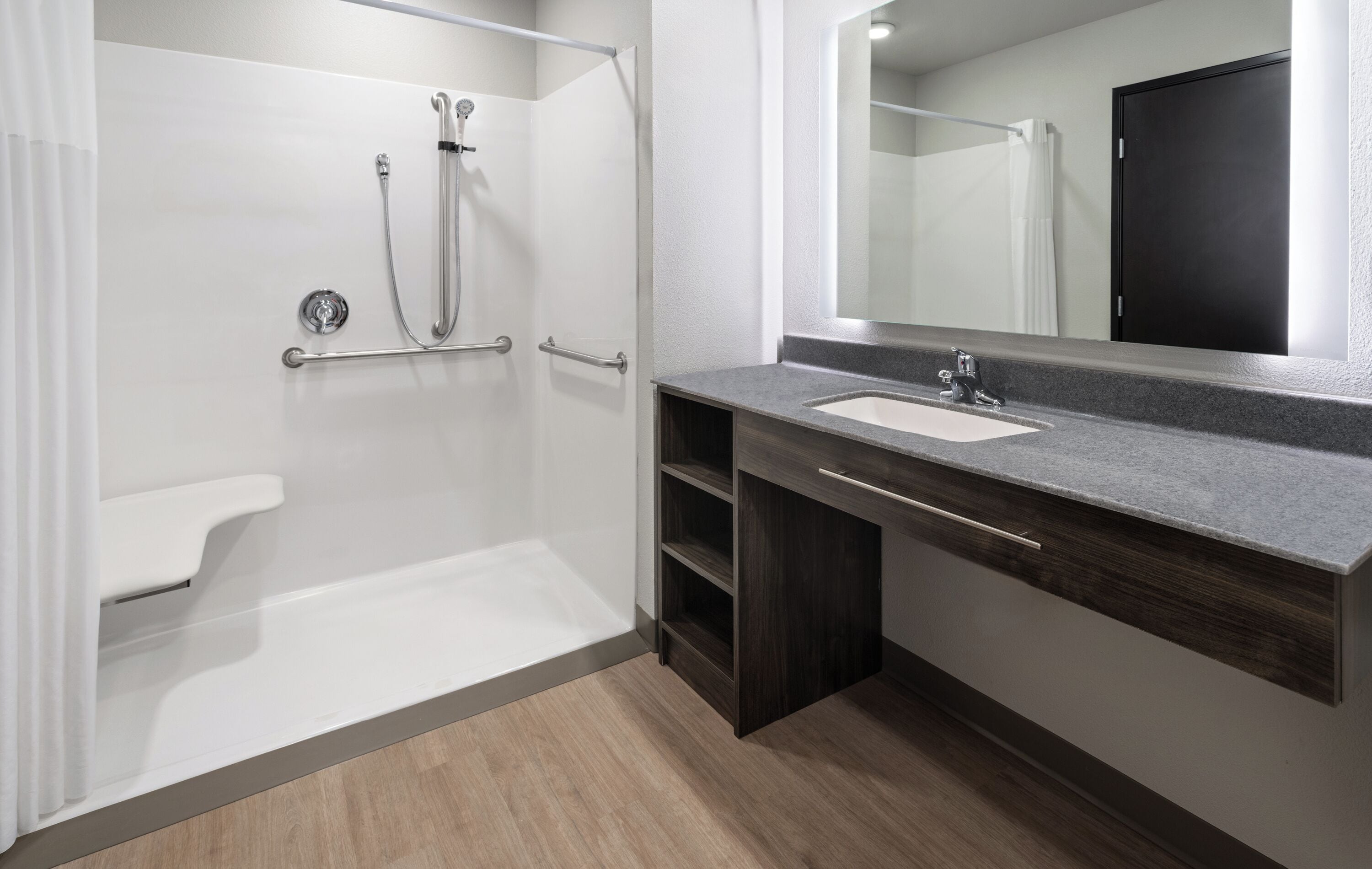 A modern bathroom with a shower, a sink, and a mirror.