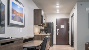 Una cocina compacta con comedor, refrigerador y microondas.