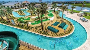 Un espace piscine doté de plusieurs toboggans et d’un terrain d’entraînement au golf.