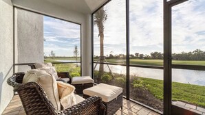 A covered patio with wicker furniture, a view of a golf course, and a body of water. - New Listing! Charlotte Harbor Area Resort, 120mi to Disney & 134mi to Universal - GRH573595 (Punta Gorda)