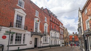 A cobblestone street lined with traditional red brick buildings, including a hotel with a sign reading "White Hart Hotel." - 17 Union Road House (Lincoln)