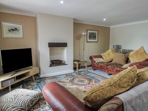 A living room with a television, sofa, and patterned rug.