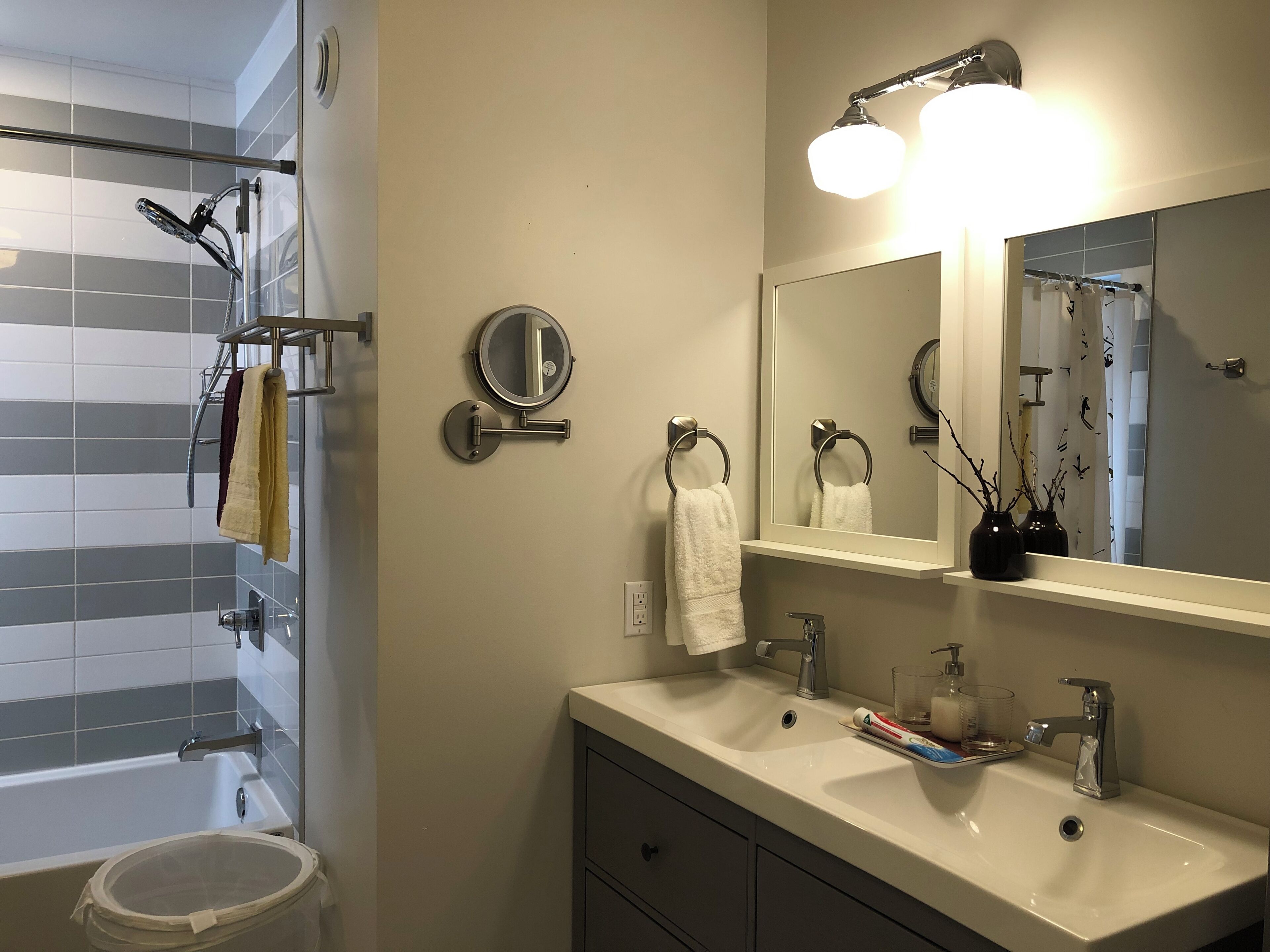 Ein modernes Badezimmer mit Badewanne, einem großen Spiegel und einem Waschtisch.