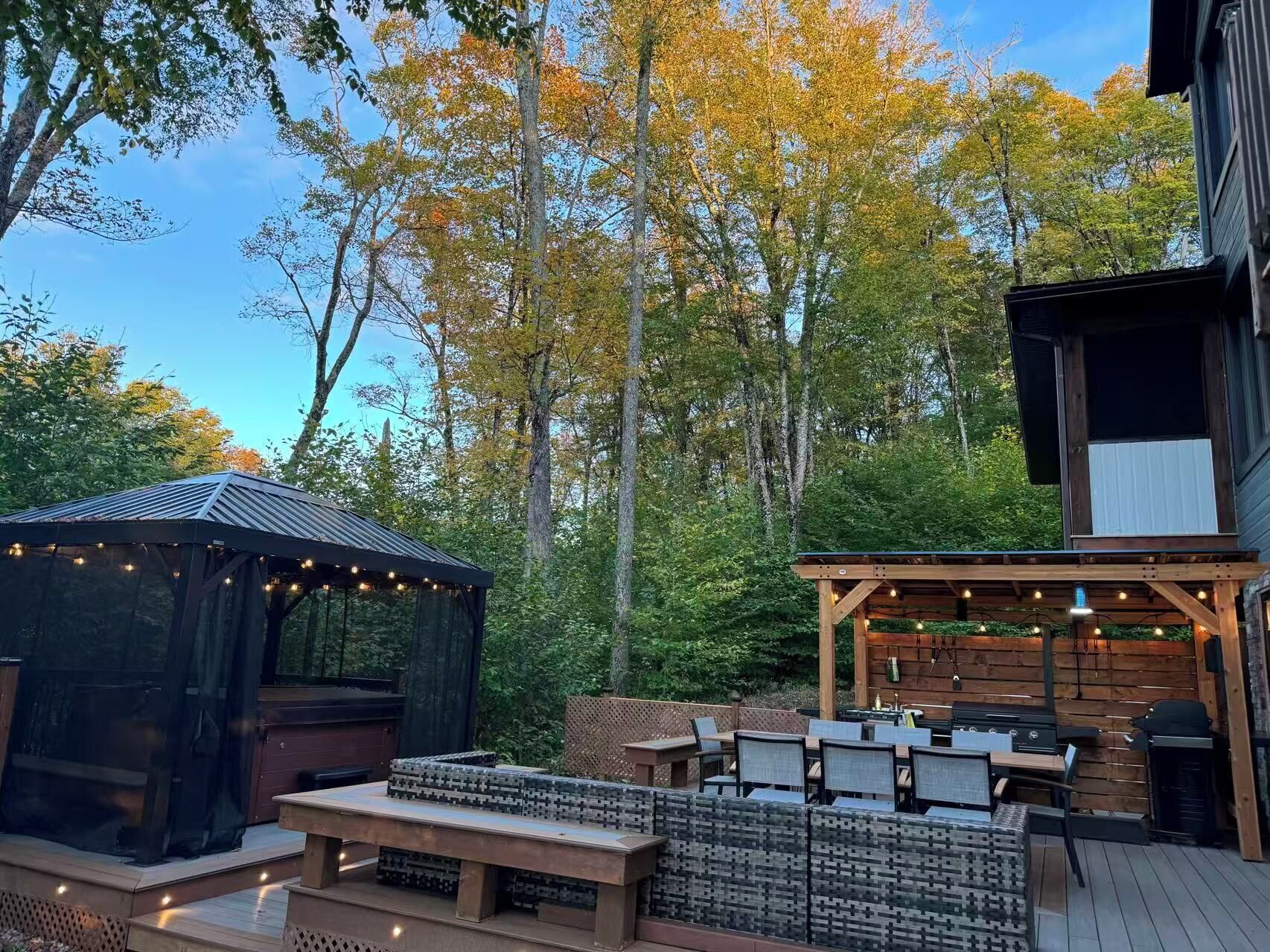 An outdoor patio area with a pergola, seating, and a barbecue grill.