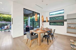 A modern dining area with a wooden table, two chairs, and hanging copper pendant lights. - LA Villa by Avantstay Walk to The Grove LA (Los Angeles)