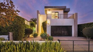 A modern two-story house with a garage, surrounded by well-maintained landscaping and a gated entrance. - LA Villa by Avantstay Walk to The Grove LA (Los Angeles)