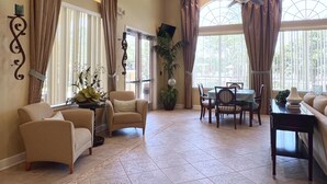 A spacious room with a dining area, two sofas, a table, and chairs.