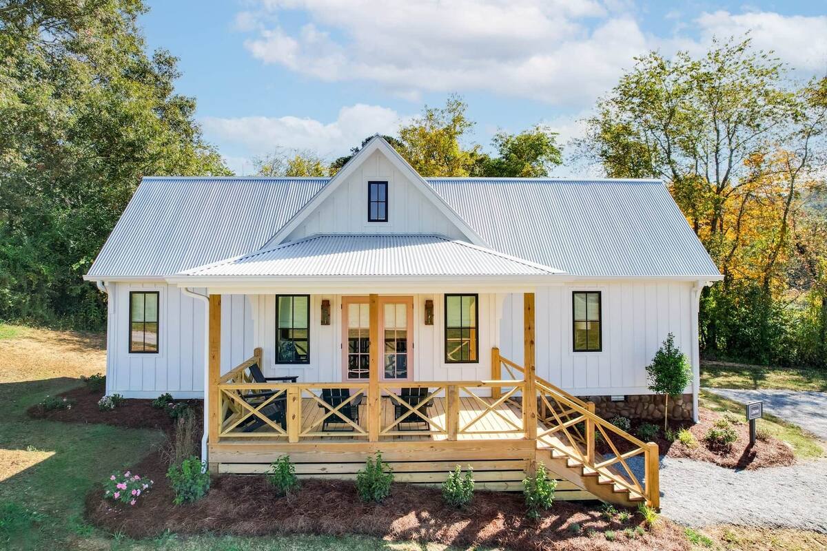 A single-story house with a porch, a covered staircase, and a metal roof.