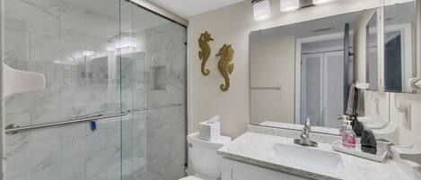 Chuveiro, secador de cabelo, toalhas de banho, papel higiênico