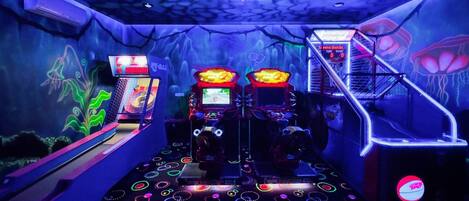 Un salón de juegos con máquinas tragamonedas iluminadas con neón y un suelo con diseños circulares.